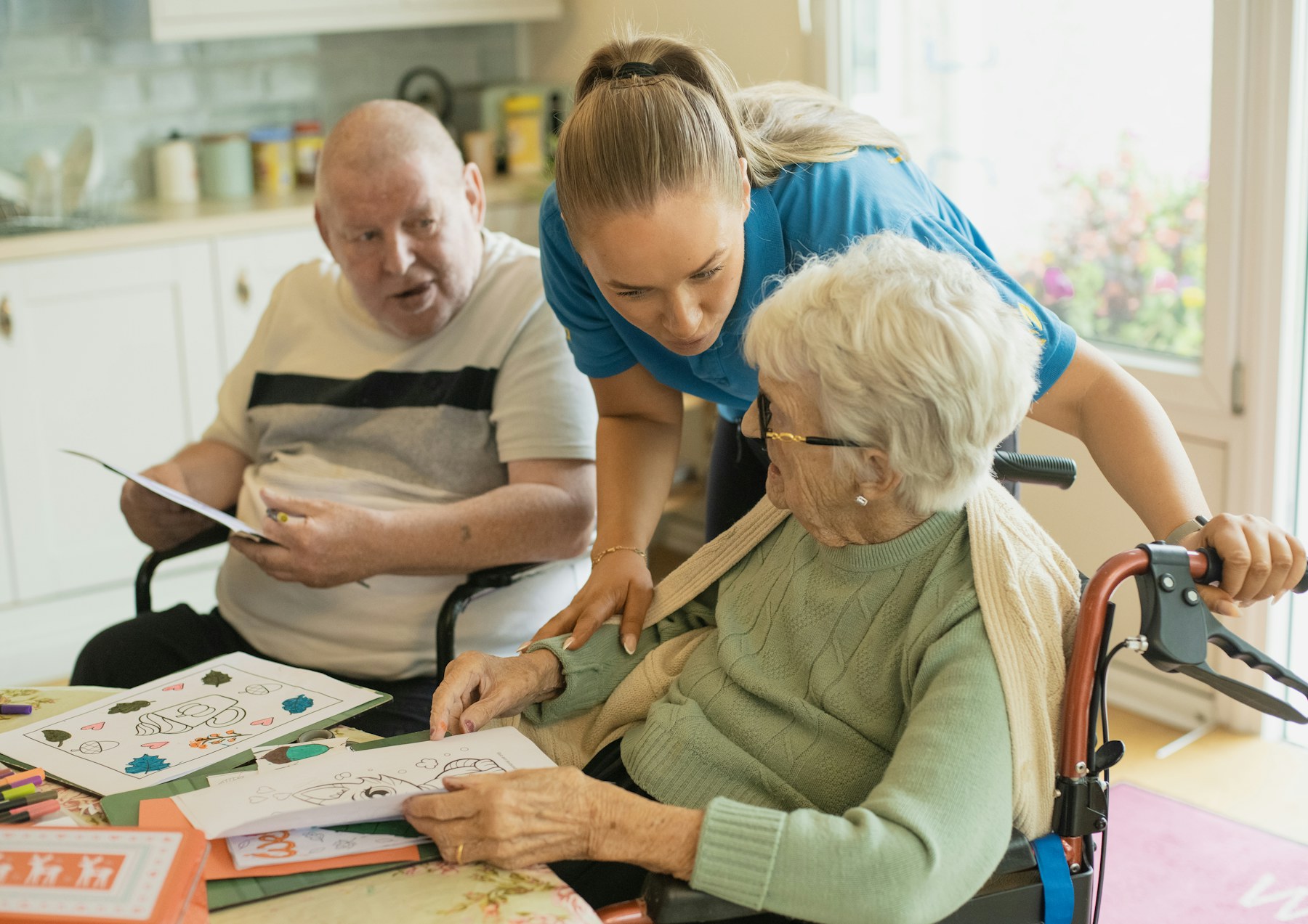 Caregiver engaging older adults in a creative activity