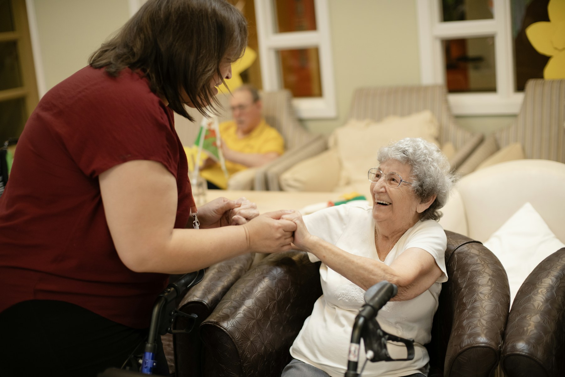 Caregiver warmly assisting an older adult with a walker